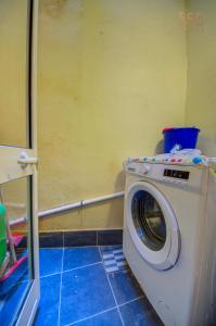 a washing machine in a bathroom with a yellow wall at Suite Victory Authentic Maltese Duplex in Birgu in Birgu