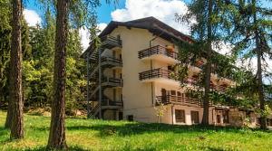 a building with trees in front of it at Garni Pirata in Cavareno