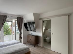 a bedroom with a bed and a television on the wall at Ostsee Hotel Travemünde in Travemünde