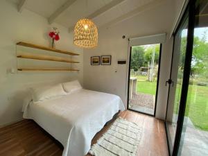 a bedroom with a bed and a large window at Laguna y Tierra in Chascomús +50 photos
