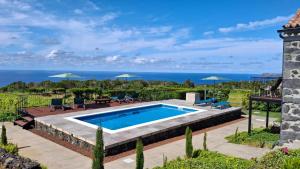 a swimming pool with a view of the ocean at Refúgio dos Capelinhos - Villa e Suites in Norte Pequeno