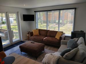 a living room with a couch and a coffee table at Luxe chalet voor gezinnen in familiepark Goolderheide met openlucht zwembaden en ruim overdekt terras 24m2 in Bocholt +19 photos