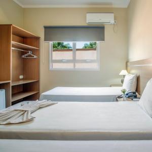 two beds in a room with a window at Hotel Stelati in Jaguariúna +37 photos