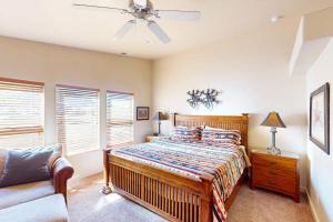 a bedroom with a bed and a couch and a ceiling fan at Rim Village O3 in Moab +26 photos