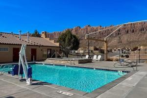 a swimming pool in front of a house with a mountain at Rim Village O3 in Moab