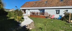 a white house with a deck and a yard at Gîte Côte et Terre in Questrecques