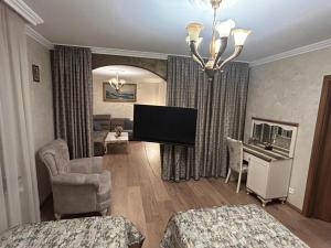 a bedroom with a living room with a television and a couch at Appartement in Oberschaeffolsheim