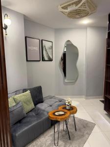 a living room with a couch and a table at AC - Studio Apartment Bahria Town in Karachi
