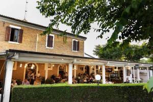 a building with people sitting at tables in front of it at La Dolce 1 in Lido di Dante