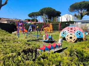 a playground with colorful play equipment in a yard at La Dolce 1 in Lido di Dante