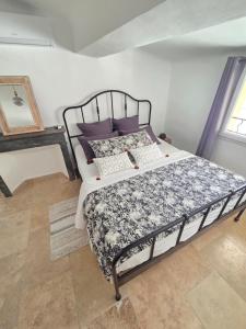 a bedroom with a bed with purple pillows at Le Beffroi de Gaston Climatisé in Aix-en-Provence