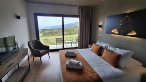 a bedroom with a large bed with a large window at Refúgio dos Capelinhos - Villa e Suites in Norte Pequeno