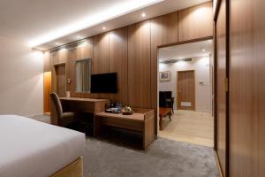 a hotel room with a bed and a desk and a mirror at Luxe Grand Hotel in Dubai