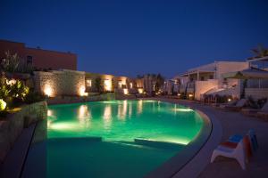 una piscina iluminada por la noche en Borgo de li Santi en Otranto