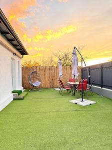 a patio with green grass and chairs and a table at CASA ELLA in Murighiol