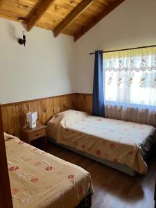 a bedroom with two beds and a window at Cabañas arca 2 in Pucón