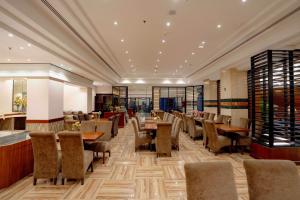 a restaurant with chairs and tables in a room at Luxe Grand Hotel in Dubai