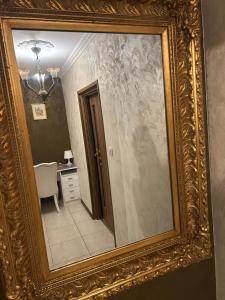 a mirror in a gold frame on a wall at Appartement in Oberschaeffolsheim +10 photos