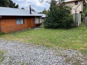 a house with a yard next to a building at Cabañas arca 2 in Pucón