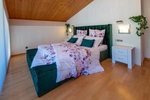 a bedroom with a large bed with a green headboard at Penthouse Jasmin in Laces