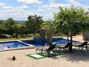 a swimming pool with chairs and a table next to at Yandheya Guest House in Calcutta