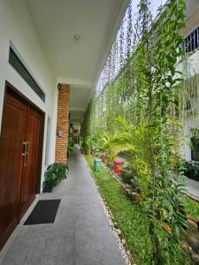 a hallway with plants on the side of a building at Rumah Tropis - Lantai 1, single room in Parit