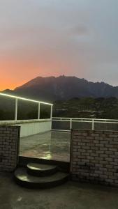 a building with a sunset in the background at Sanhill & Oasis in Ranau