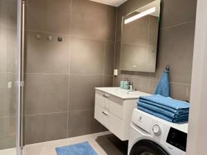 a bathroom with a sink and a shower at Apartment by Kokstad tram in Bergen +6 photos
