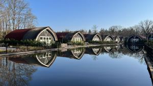 a row of domed houses sitting on the water at 't Landgoed Baars in Baars