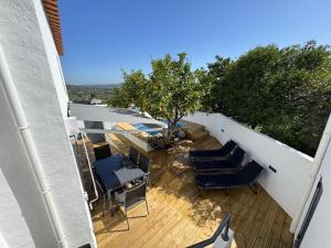 a balcony with chairs and a table and a tree at Á-do-Couve in Alvito