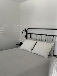 a white bed with white pillows and a lamp at Á-do-Couve in Alvito +36 photos
