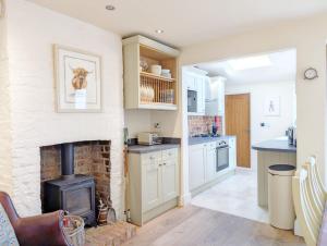 a kitchen with a brick fireplace and a stove at Compass Cottage , Emsworth in Emsworth +23 photos