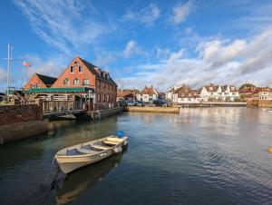 a boat is docked in the water in a town at Compass Cottage , Emsworth in Emsworth