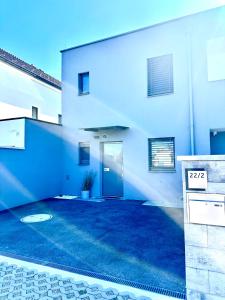 a white building with a door and a driveway at Skyline-View in Gerasdorf bei Wien