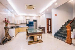 a kitchen with a glass table and a staircase at Happy Villa in Sầm Sơn