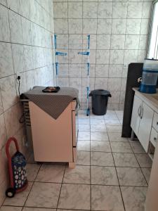 a kitchen with a table in a tiled room at Apto inteiro 2 quartos Elvamar in Governador Valadares