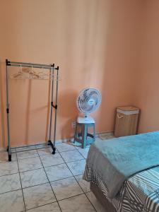 a room with a fan next to a bed at Apto inteiro 2 quartos Elvamar in Governador Valadares +1 photo