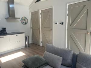 a living room with a couch and a sliding barn door at Zon en Zee 2 personen in Westkapelle