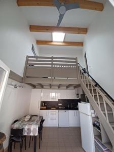 a kitchen with a staircase and a table in a room at maison 100 m de la plage à pieds in Portiragnes