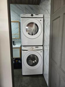 a washing machine and a washer in a bathroom at Paso de las Lapas in Uvita