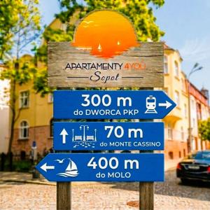 a street sign with several signs on it at Apartamenty4you - SleepWell Apartment in Sopot