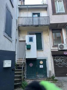 a building with a green door and a balcony at Studio cosy avec extérieur CHU in La Tronche