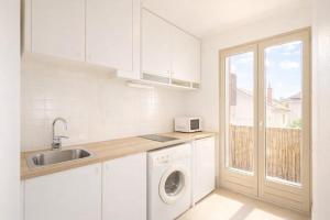 a white kitchen with a sink and a washing machine at Studio cosy avec extérieur CHU in La Tronche