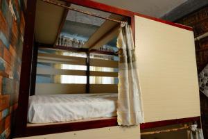 a bunk bed with a curtain in a room at Bụi Homestay - Ferry to Rạch Giá in Rạch Giá