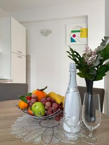 a bowl of fruit on a table with a bottle and a vase at Villa ARINA - Apartments 20 m from Beach, Tucepi in Tučepi