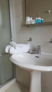 uma casa de banho com um lavatório branco e toalhas em Hotel Calaluna em Biella