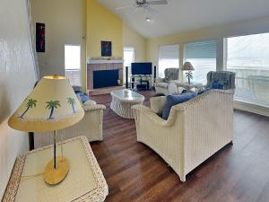 a living room with couches and a table with a lamp at Whispering Sands Beachfront in Galveston
