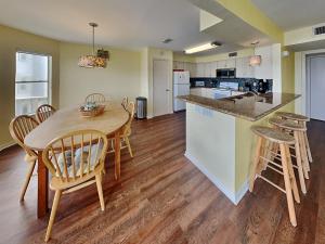 a kitchen and dining room with a wooden table and chairs at Whispering Sands Beachfront in Galveston