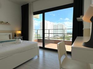 a bedroom with a white bed and a large window at Nothern Cyprus Caesar Resort & Spa Collection Pools & Long Beach in Aglantzia +240 photos