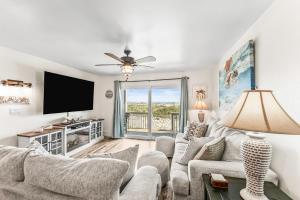 a living room with a couch and a flat screen tv at Oceanfront St Helena Island Condo w/ Beach Access! in Oceanmarsh Subdivision